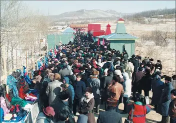  ??  ?? Chinese and Russian people attend a civil trade market in Suifenhe, which borders Russia, in 1990.