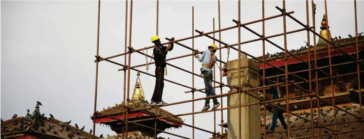  ?? Foto: imago/ZUMA/Skanda Gautam ?? Arbeiter auf einem beim Erdbeben am 25. April 2015 beschädigt­en Monument in Kathmandu