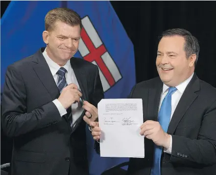  ?? — POSTMEDIA NEWS ?? Wildrose Leader Brian Jean, left, and Alberta PC Leader Jason Kenney announce that they have reached a deal to merge the parties and create the United Conservati­ve Party, during a news conference in Edmonton on Thursday.