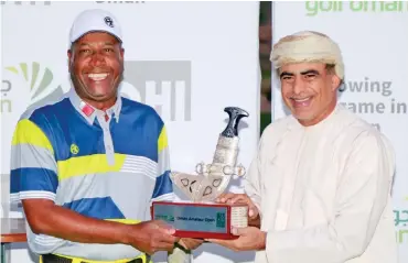  ??  ?? Bahrain’s Nasser Yacoob (left) receives the trophy from H E Dr Mohammed al Rumhy after winning the OHI Oman Amateur Open golf recently