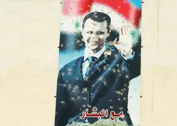  ?? (Reuters) ?? A DAMAGED picture of Syrian president Bashar Assad is seen on a wall in northern Syria.