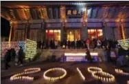  ?? THE ASSOCIATED PRESS ?? Buddhists light candles during New Year celebratio­ns at Jogyesa Buddhist temple in Seoul, South Korea, early today.