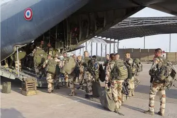  ??  ?? Geared for action: French soldiers of the 21st Marine Infantry Regiment boarding the plane to Bamako at the N’Djamena’s airport in Chad. — AP
