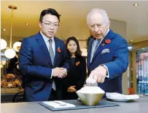  ?? Courtesy of Kim Jong-soon ?? King Charles III, right, speaks with Kim Jong-soon, CEO of JS Holdings, at Kim’s Korean dessert cafe Cake & Bing Soo in New Malden, England, in this November 2023 photo. The king visited the community ahead of the state visit by Korean President Yoon Suk Yeol.