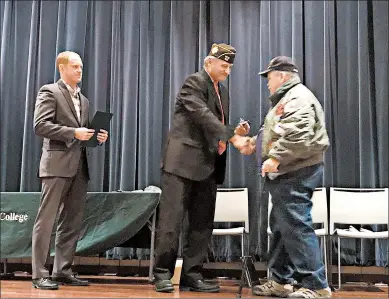  ?? TED SLOWIK/DAILY SOUTHTOWN PHOTOS ?? Russell Litko, left, assistant director of the Illinois Department of Veterans Affairs, and Richton Park Mayor Rick Reinbold present a pin to a VietnamWar veteran during an event Thursday at Prairie State College in Chicago Heights.
