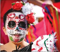  ??  ?? A face-painted marcher in the Mexican entry during the Calgary Stampede parade in Calgary, Friday