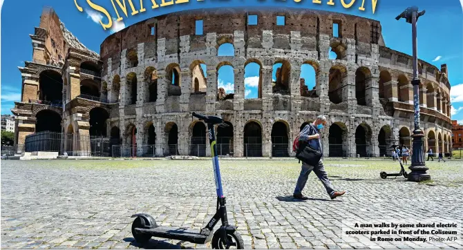  ?? Photo: AFP ?? A man walks by some shared electric scooters parked in front of the Coliseum in Rome on Monday.