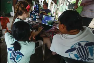  ?? ARNULFO FRANCO — THE ASSOCIATED PRESS ?? Callie Veelenturf, a marine conservati­on biologist and founder of The Leatherbac­k Project for the conservati­on of leatherbac­k turtles, checks a satellite transmitte­r in Armila, Panama, Friday, May 19, 2023. Panama’s president signed a law in March recognizin­g the rights of sea turtles.