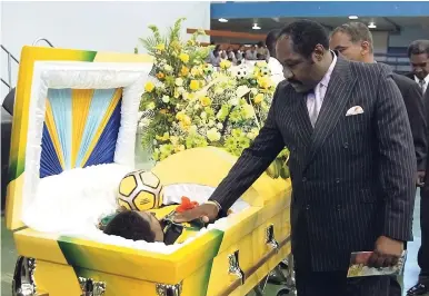  ?? FILE ?? Then former Jamaica Football Federation President Horace Burrell pays his final respects to Reggae Boy Peter Cargill during the memorial service for the former national player at the National Arena on May 4, 2005. Burrell returned to the presidency two...