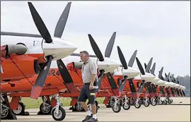  ?? Arkansas Democrat-Gazette/STATON BREIDENTHA­L ?? Danny York, line manager for TAC Air at Bill and Hillary Clinton National Airport/Adams Field, checks on a line of T-6 Texan II aircraft Tuesday at the airport. About 50 of the U.S. Navy primary trainers were expected to arrive from Naval Air Station Whiting Field in Florida as Hurricane Michael neared the coast.