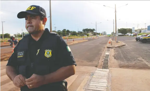  ?? PHOTOS: TERRENCE MCCOY/THE WASHINGTON POST ?? Police officer Flavio Adriano Dourado keeps watch over a highway in Dourados, Mato Grosso do Sul state, in Brazil. The country has seen a dramatic increase in the amount of illegal pesticides crossing its borders in recent years. About 10 per cent of the agrochemic­al trade is illegal, according to the OECD.