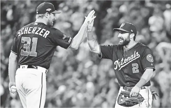  ?? BRAD MILLS/USA TODAY SPORTS ?? Max Scherzer, who won Game 2 of the NLCS, and right fielder Adam Eaton celebrate after the Nationals won Game 3 8-1 Oct. 14 to take a 3-0 series lead on the Cardinals.