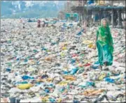  ?? SHASHI KASHYAP/HT ?? A woman walks on Versova beach, among the worst affected, ▪ where around 15,000kg of waste has washed up.