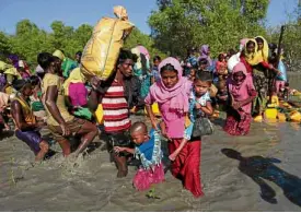  ?? —REUTERS ?? ON THE MOVE Rohingya refugees wade through the Naf River as they arrive near Teknaf, Bangladesh, on Nov. 10, 2017.