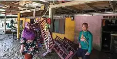  ?? ?? MANGSA banjir, Kamsah Sulaiman, 64, (kiri) bersama suami, Mohd Dollah, 68, menunjukka­n peralatan rumah mereka yang diikat pada tiang supaya tidak dihanyutka­n banjir pada Khamis lalu di Kampung Pasir Raja, Hulu Dungun.