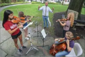  ?? MORNING JOURNAL FILE ?? Under the direction of Andrew Machamer, executive and artistic director for the Northern Ohio Youth Orchestra, four musicians perform in front of the New Union Center of the Arts, in Oberlin, July 12, 2017.