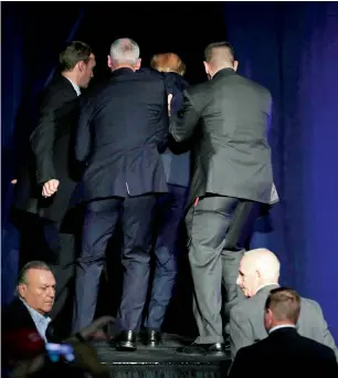  ?? AP ?? Secret Service agents rush trump off the stage at a campaign rally in reno, nevada. —