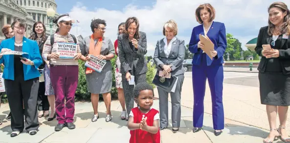  ??  ?? Hawa Tembe, cuya mamá es de Mozambique, aplaude durante una protesta de legislador­as estadounid­enses afuera del Capitolio, en Washington, contra la política de separar familias migrantes.