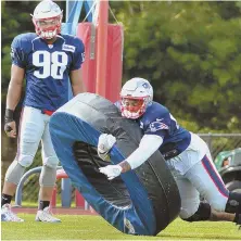  ?? STaFF phoTo bY ChRIs ChRIsTo ?? TAKE HOLD OF THE WHEEL: Trey Flowers (left) watches teammate Frank Herron go through a tackling drill during yesterday’s Patriots training camp in Foxboro.