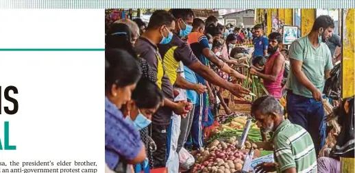  ?? AFP PIC ?? People buying vegetables at a market after authoritie­s relaxed the curfew for a few hours in Colombo yesterday.