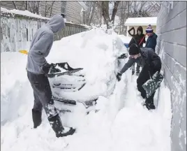  ?? CP PHoto ?? People remove snow from around a car yesterday in Dartmouth.