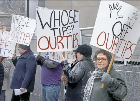  ?? Darrell Sapp/Post-Gazette ?? Marjorie Simons, right, of Collier, displays her sign with other members of the Restaurant Opportunit­ies Center United.