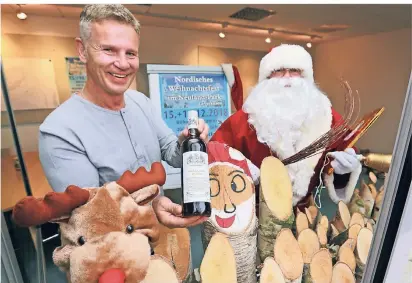  ?? FOTO: UWE MISERIUS ?? Freuen sich auf den nordischen Weihnachts­markt: Armin Kühler mit einer Flasche Glögg und der nordische Weihnachts­mann Joulupukki.