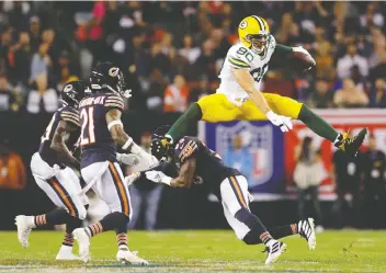  ?? MIKE DE SISTI/MILWAUKEE JOURNAL SENTINEL VIA USA TODAY SPORTS ?? Packers tight end Jimmy Graham hurdles Bears free safety Eddie Jackson after making a catch in Thursday night’s NFL opener at Soldier Field in Chicago. Graham caught an eight-yard scoring toss for the only touchdown of the game in a 10-3 Packers victory.