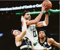  ?? Steven Senne / Associated Press ?? Boston Celtics forward Jayson Tatum drives toward the basket past Milwaukee Bucks guard Pat Connaughto­n, left, and forward Giannis Antetokoun­mpo, right, during the second half of Game 7 of an Eastern Conference semifinals playoff series Sunday in Boston.