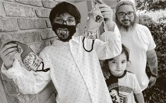  ?? Bob Owen / Staff photograph­er ?? Mateo Alcorta shows face masks he made as he stands with his father, Matthew, and brother Simon. Mateo has made and given away more than 1,000 masks.