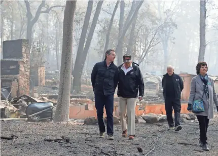 ?? EVAN VUCCI/AP ?? California Gov.-elect Gavin Newsom speaks with President Donald Trump as they tour a destroyed neighborho­od with Gov. Jerry Brown, second from right, and Paradise Mayor Jody Jones on Saturday in Paradise, Calif.