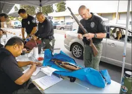  ?? NANCEE E. LEWIS FOR THE U-T ?? Dana Duplesis, from Poway, waits in a car Saturday after turning in her deceased father’s guns at a guns-for-gift-cards event Saturday in Chula Vista.