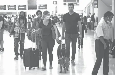  ?? ANDREA MURCIA/CUARTOSCUR­O ?? Turistas nacionales
y extranjero­s llegan al Aeropuerto Internacio­nal de Cancún