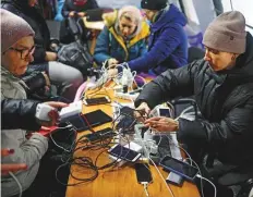  ?? Reuters ?? ■
Residents charge their devices, use internet and warm up inside an invincibil­ity centre after critical civil infrastruc­ture was hit by Russian missile attacks in Kyiv, yesterday.