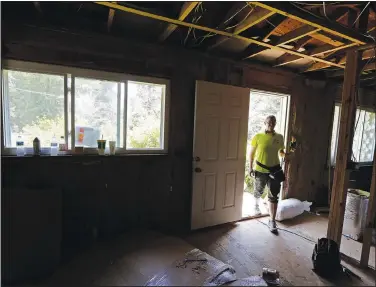  ?? (File Photo/AP/Gerry Broome) ?? Homeowner Jennifer Baker walks July 2, 2019, through the front door of her home damaged by Hurricane Florence in 2018 while repairs continue in Spring Lake.