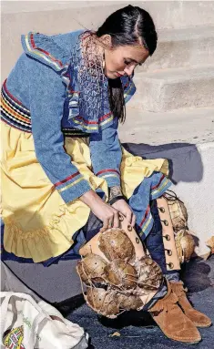  ?? [PHOTO PROVIDED] ?? Cotie Poe, of Millcreek, prepares elements of her traditiona­l, Native American clothing, during a performanc­e at the closing event for Native American Heritage Month in 2017.