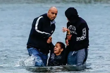  ?? Photos by Jessica Phelps / Staff photograph­er ?? Carlos Luis Rivero, left, and a suspected smuggler help Rivero’s mother-in-law, Belkis Salas, in the Rio Grande.