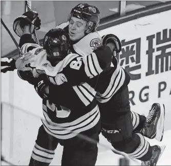  ?? CHARLES KRUPA/AP PHOTO ?? Boston’s Charlie McAvoy leaps into the arms of Brad Marchand after scoring in overtime of the team’s 4-3 win over Carolina at TD Garden.