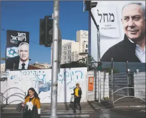  ?? The Associated Press ?? PEOPLE PASSING: People walk next to election campaign billboard on March 1, showing Israeli Prime Minister Benjamin Netanyahu, right, and Benny Gantz, left, in Bnei Brak, Israel. Israel’s president on Sunday, turned down a request from Blue and White party leader Benny Gantz for a two-week extension to form a new coalition government.