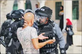 ?? Ahmad Gharabli AFP/Getty Images ?? AN ISRAELI policeman confronts a Palestinia­n in Jerusalem at a site Muslims refer to as the Al Aqsa mosque compound and Jews refer to as the Temple Mount.