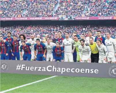  ?? Afp ?? Jugadores de Barcelona y Real Madrid, intercalad­os durante el minuto de silencio