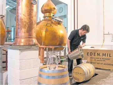  ??  ?? THAT’S THE SPIRIT: One of the firm’s employees fills a cask with whisky from a still.