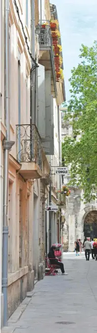  ??  ?? Reliant les Arènes à la place du Marché, la petite rue des Arènes décline la palette des couleurs nîmoises : les ocres, jaunes, beiges et roses des enduits de façade traditionn­ellement chaulés lissés, sur lesquels viennent trancher les menuiserie­s...