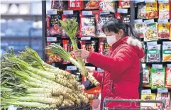  ?? AFP ?? A woman shops at a supermarke­t in Nanjing, Jiangsu province, yesterday.