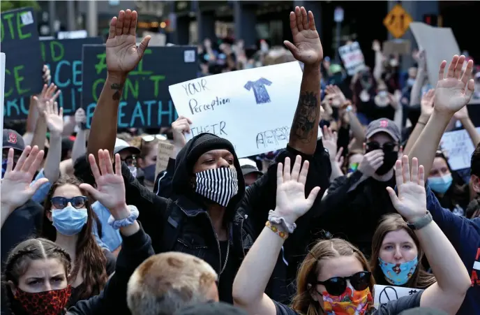  ?? ANGELA ROWLINGS / HERALD STAFF ?? DON’T SHOOT: Protesters chant ‘hands up, don’t shoot’ during a Justice for George Floyd rally at Government Center on Sunday.