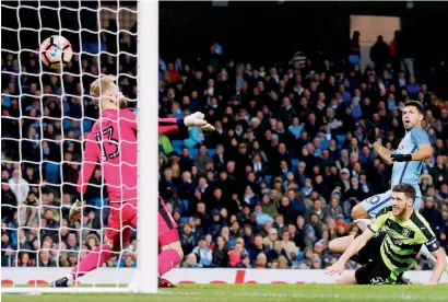  ?? Reuters ?? Aguero scores a goal past Huddersfie­lds goalkeeper during FA Cup fifth round at Etihad Stadium. —