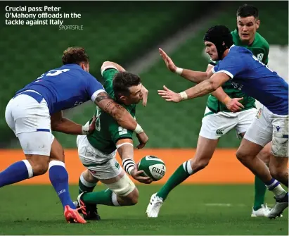  ?? SPORTSFILE ?? Crucial pass: Peter O’Mahony offloads in the tackle against Italy