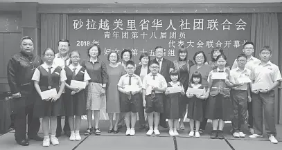  ??  ?? DIHARGAI: Hii (barisan belakang, enam kanan) dan jawatankua­sa Seksyen Wanita dan Belia bergambar bersama penerima bantuan pendidikan.