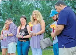  ?? JASON BEEDE ?? Family members and friends of London Harrell, a student who was critically injured in a hit-and-run crash, gather Friday night for a vigil at the University of Central Florida reflection pond.