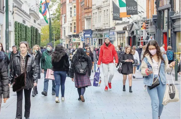  ??  ?? ↑
Shoppers walk through a busy Grafton Street in Dublin, Ireland, on Friday. Ireland’s economy rose by 3.4% in 2020 despite the pandemic.